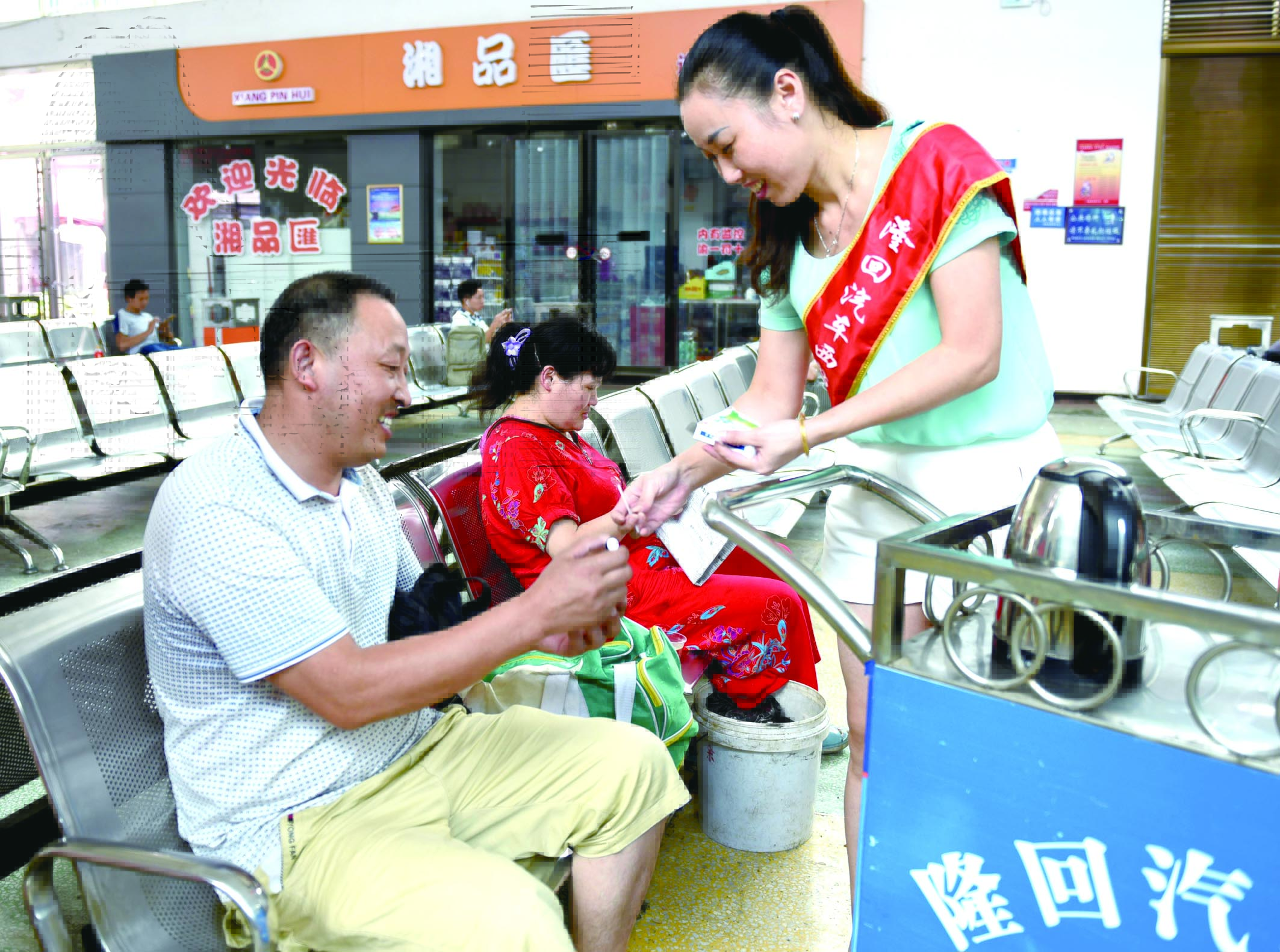 隆回分公司汽车西站工作人员正在为旅客免费赠送藿香正气水。